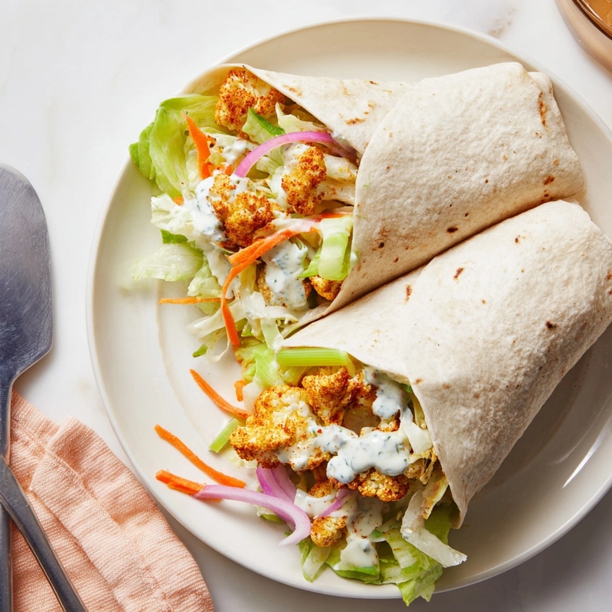 Spicy Buffalo Cauliflower Wraps dripping with blue cheese dressing, a crave-worthy vegetarian dinner.