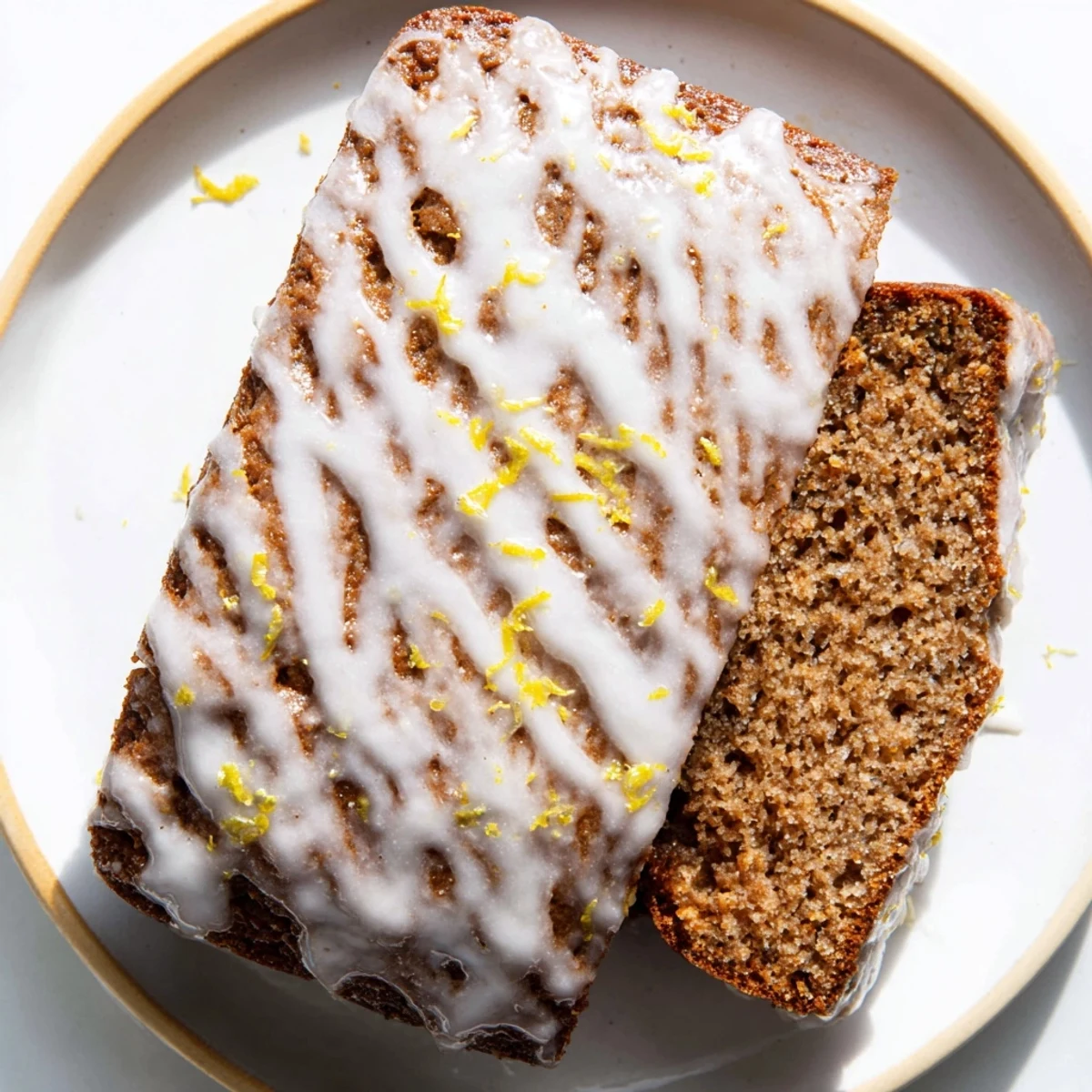 Warm gingerbread loaf cake with lemon glaze drizzled on top, ready to serve and enjoy.