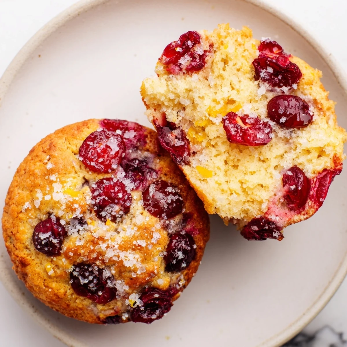 Freshly baked Cranberry Orange Muffin Tops, showing juicy cranberries peeking from the tender, airy texture.