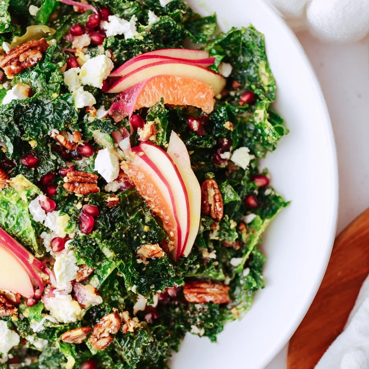 Vibrant Winter Kale Salad with Pomegranate, showing juicy red pomegranate contrasted with green kale.