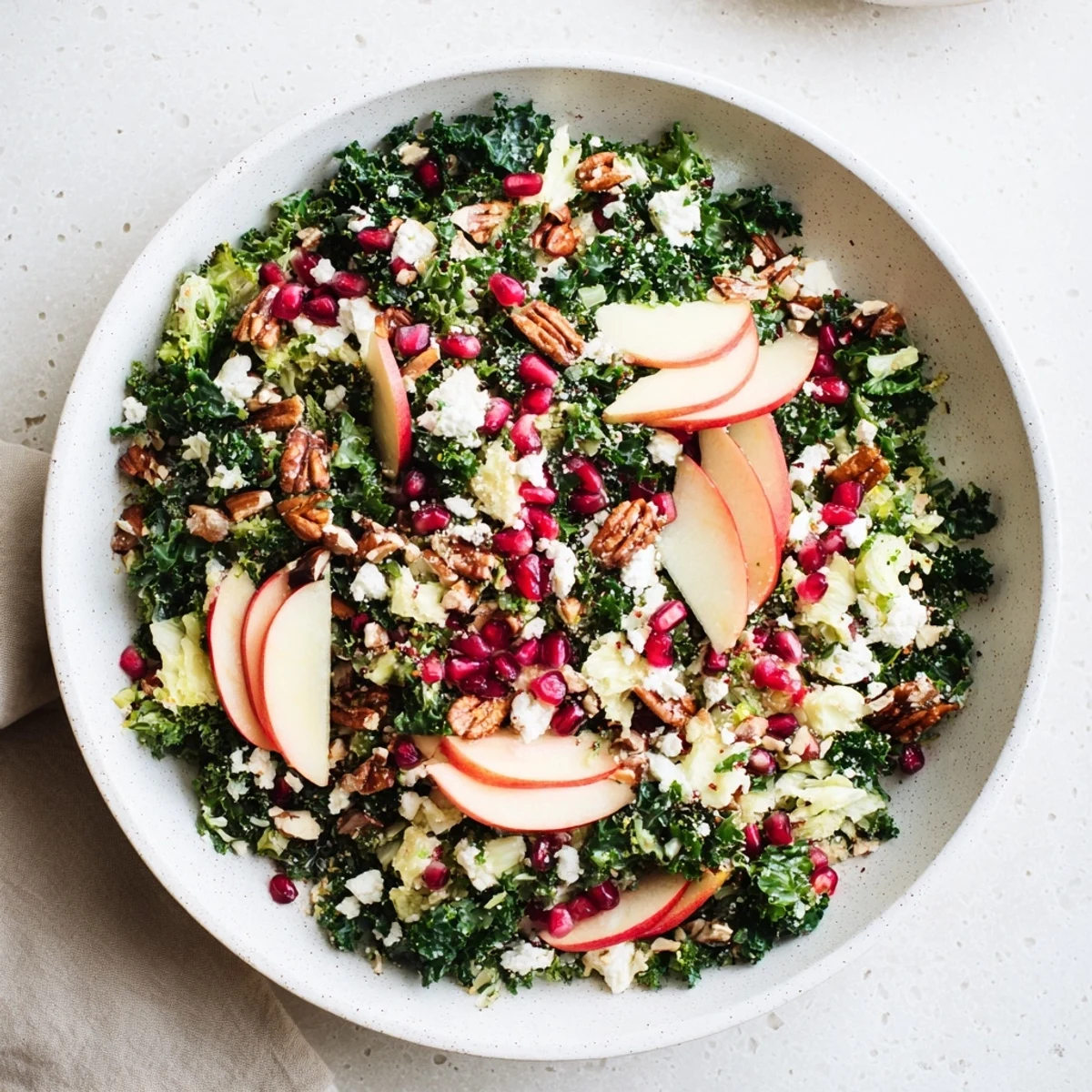 A healthy bowl of Winter Kale Salad with Pomegranate, ready to enjoy at a seasonal gathering, full of color.