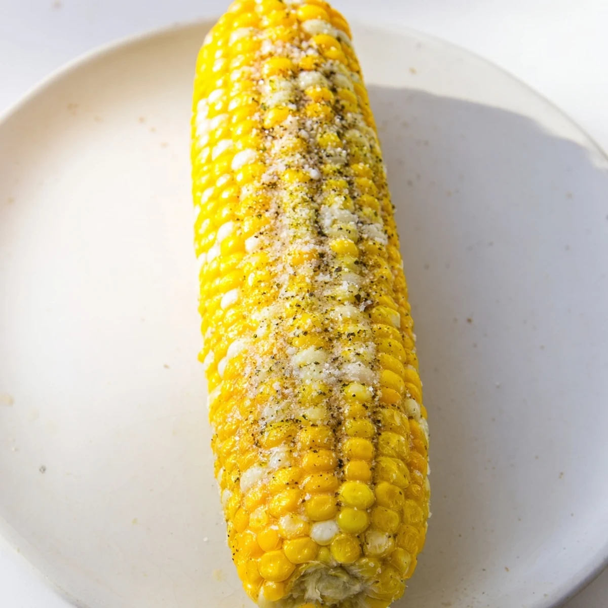 Steaming golden corn on the cob, a classic American side, generously buttered and seasoned.