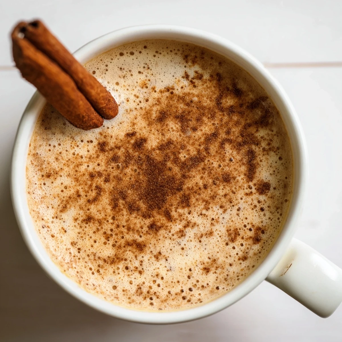 Steaming cup of Spiced Chai Tea Latte with Cinnamon dusted on top, served cozy and sweet.