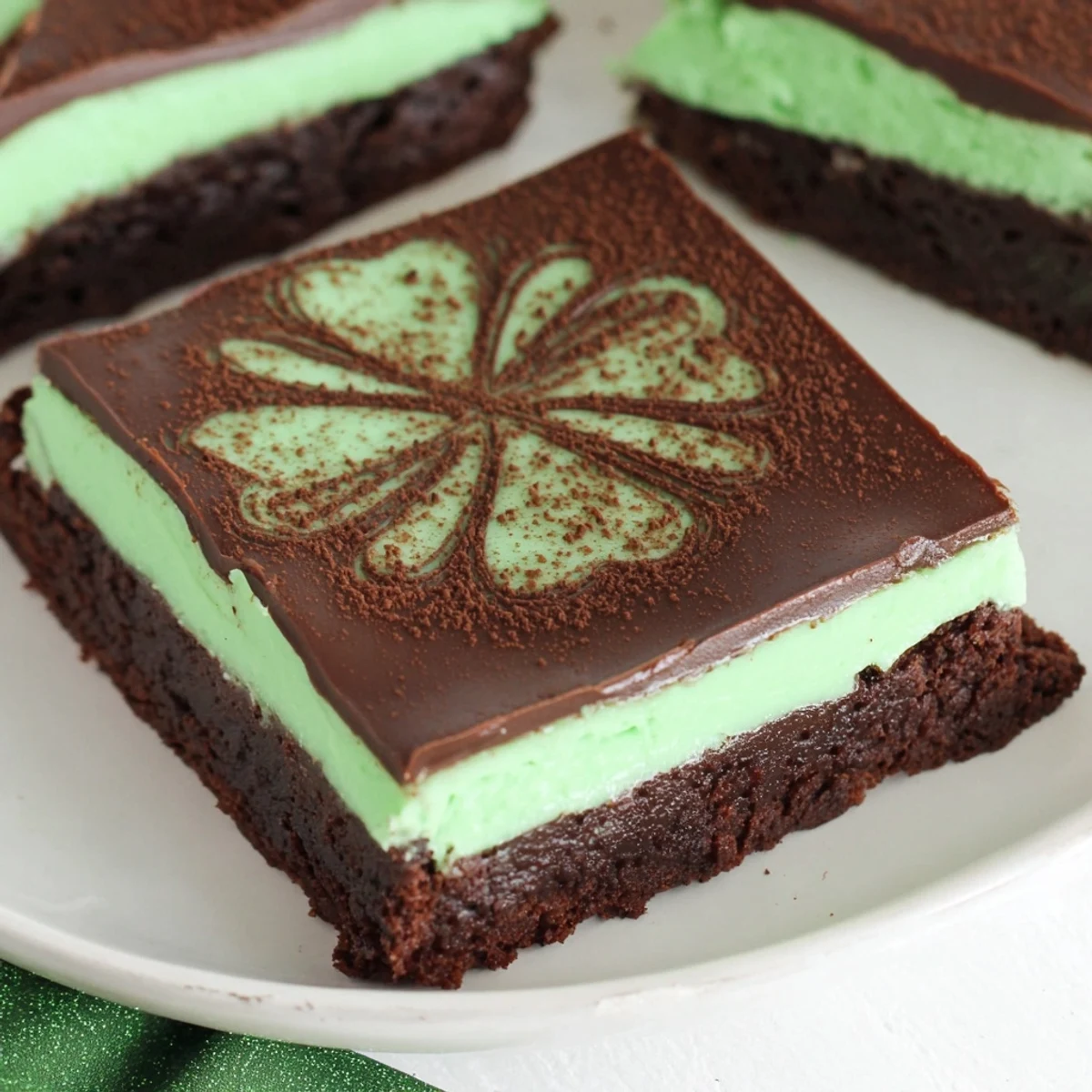 A close-up of Shamrock Mint Brownies with Ganache, showcasing rich dark chocolate ganache over a vibrant green mint cream layer.