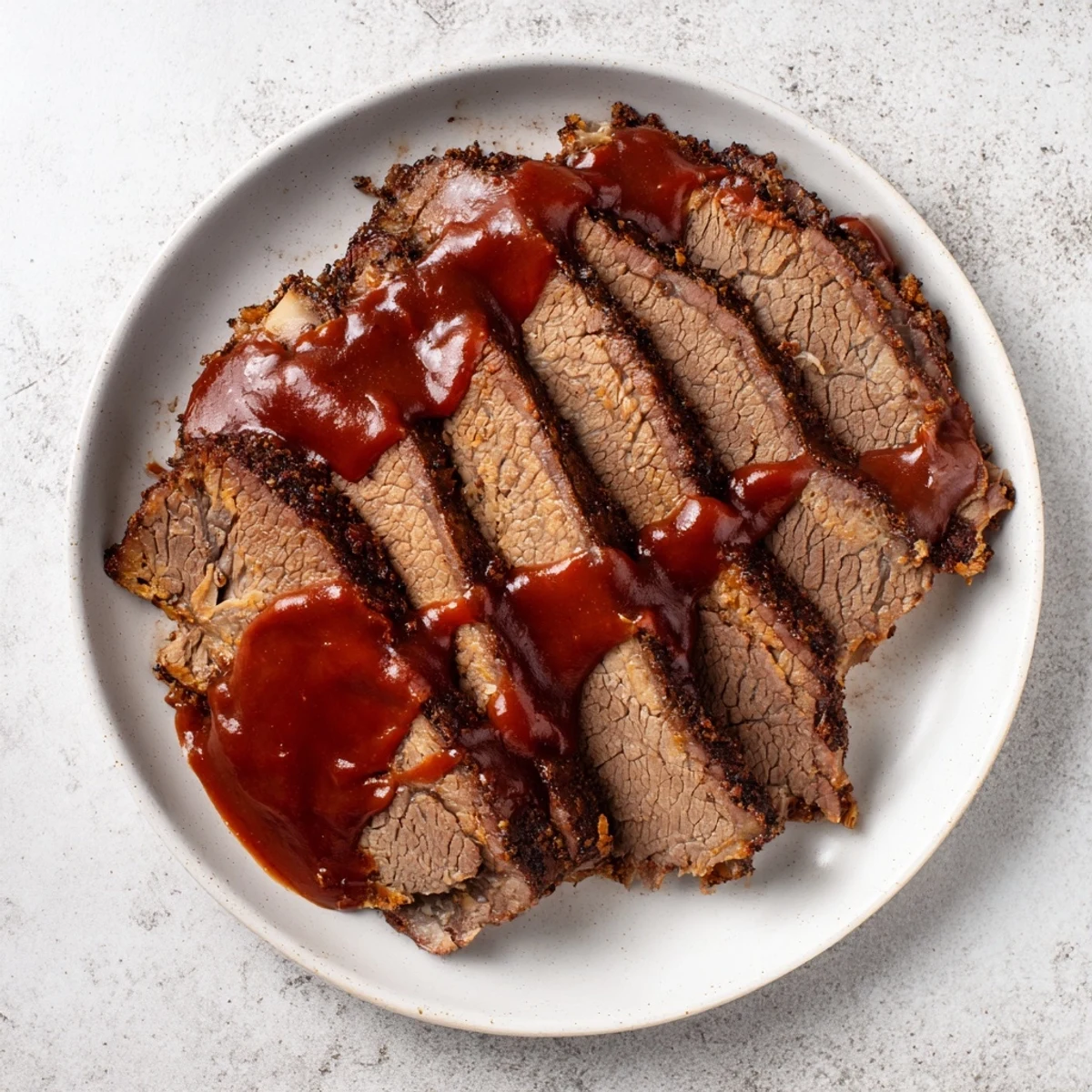 Tender, melt-in-your-mouth slow cooked beef brisket with BBQ sauce, drizzled and garnished for a hearty American meal.