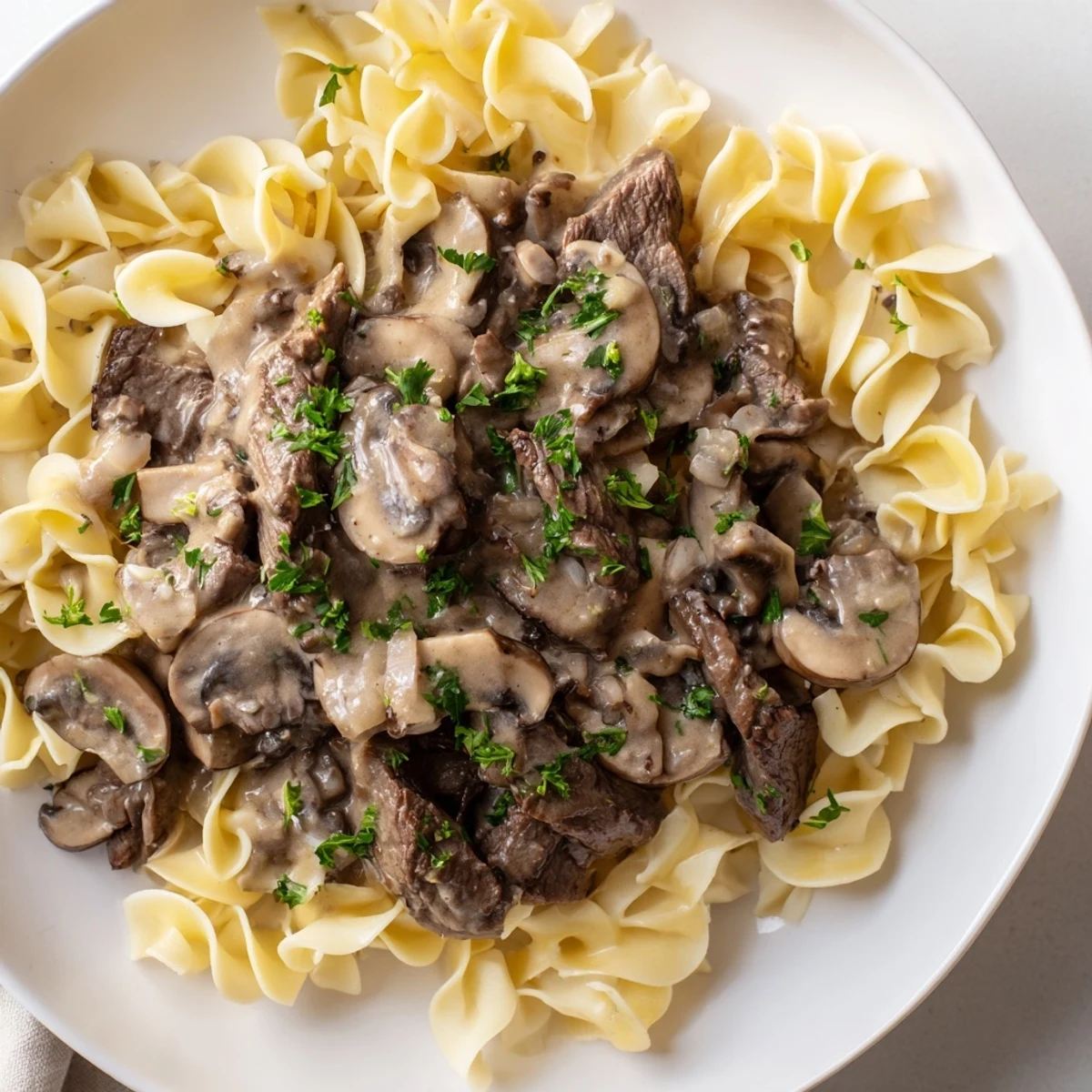 Tender beef strips in creamy mushroom sauce over buttery egg noodles for Beef Stroganoff.