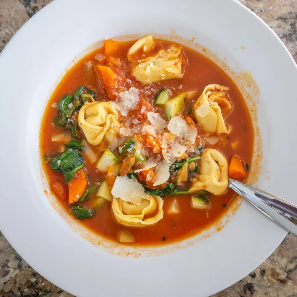 Hearty One Pot Creamy Tomato Tortellini Soup in a pot with spinach and cheese-filled tortellini.