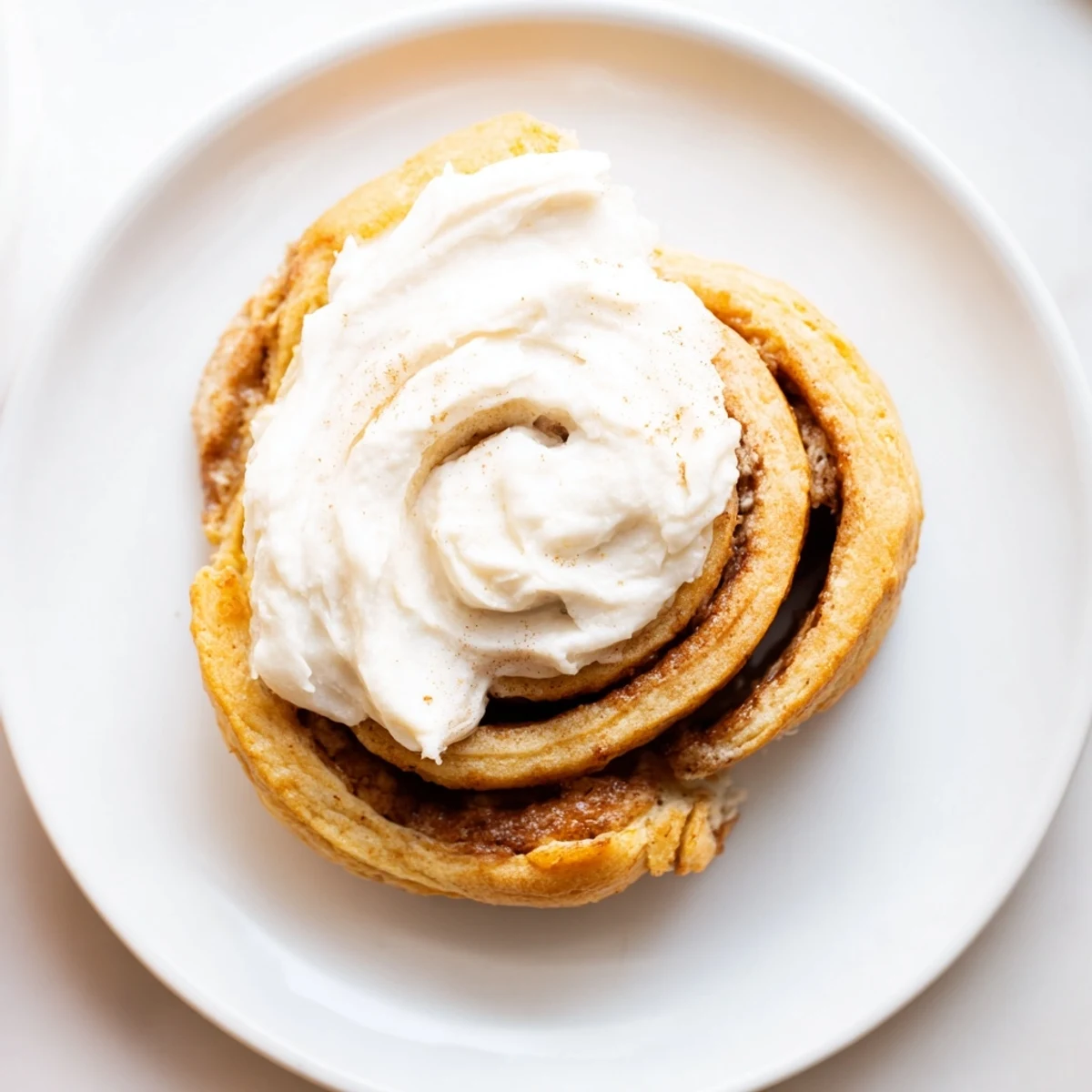 Golden Keto Cinnamon Buns on a white plate with a cup of coffee, ready for a low-carb breakfast treat.