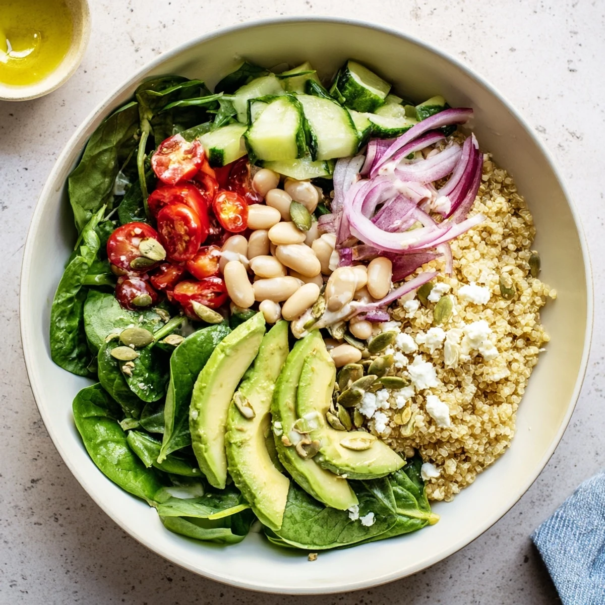 The Spinach & White Bean Ultimate Protein Power Bowl features a generous drizzle of tangy lemon-tahini dressing and crunchy pumpkin seeds.