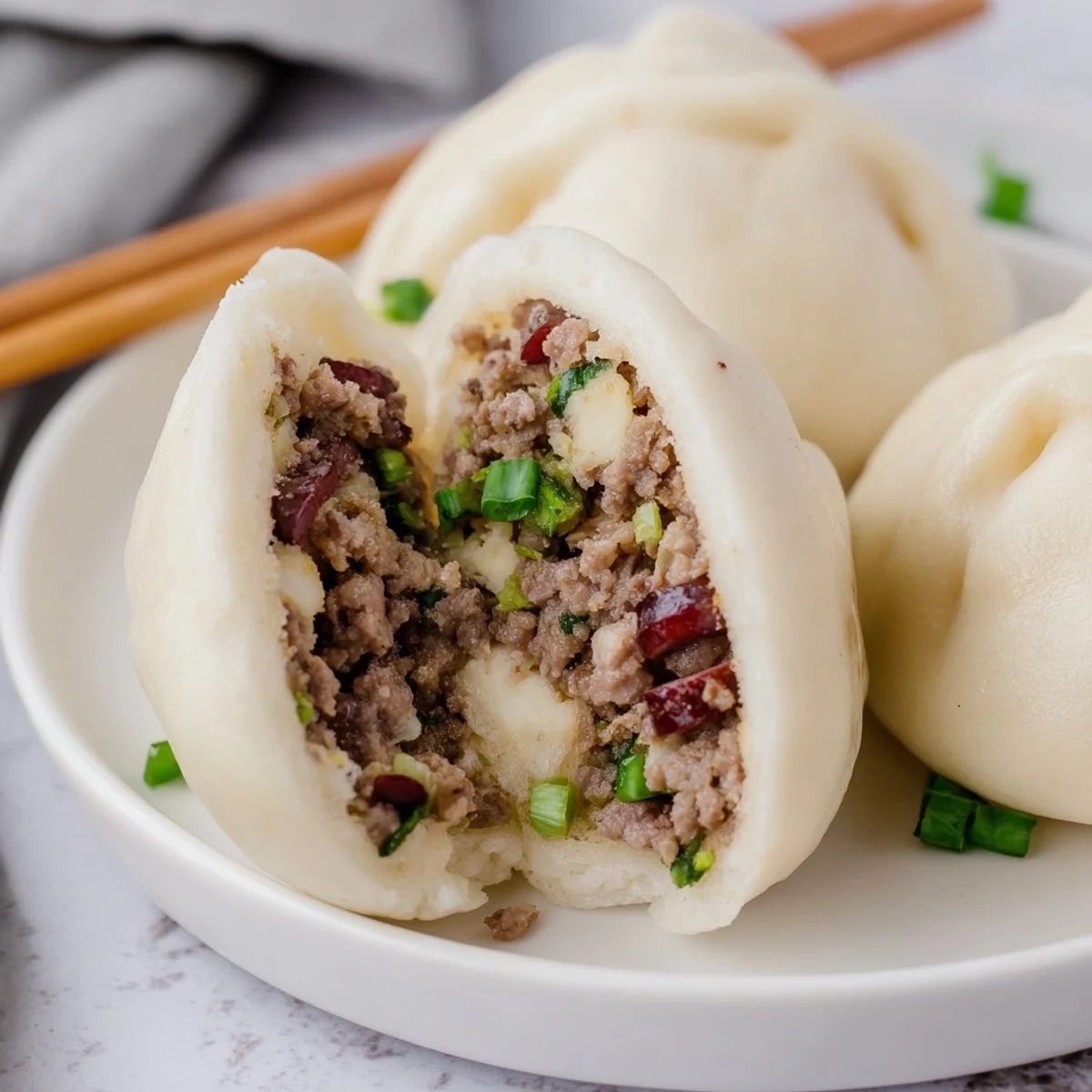 A close up of Banh Bao showcasing its soft white bun and rich pork egg filling.