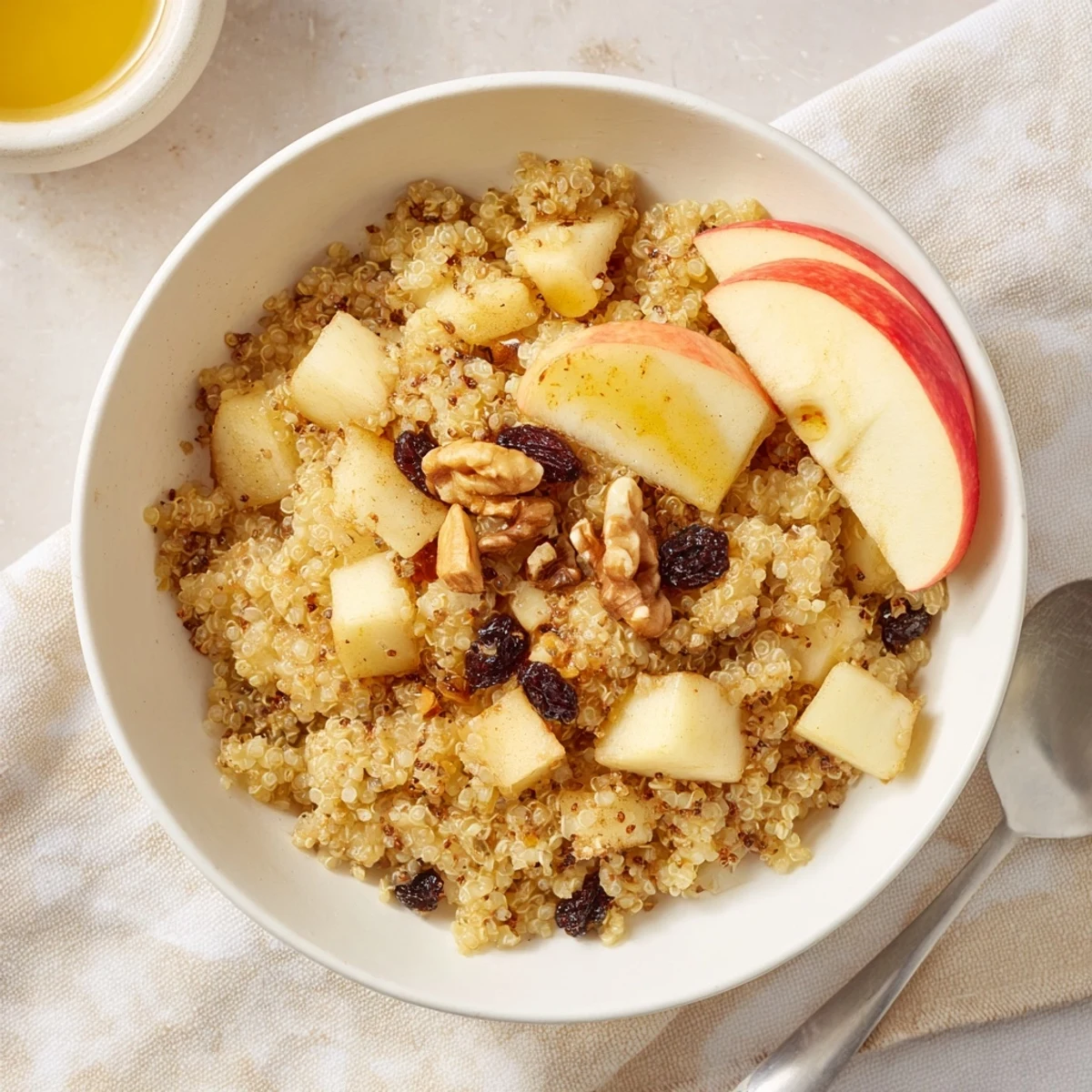 Steaming bowl of Healthy Quinoa Apple Breakfast with tender apples and cinnamon, ready to serve with a drizzle of honey.