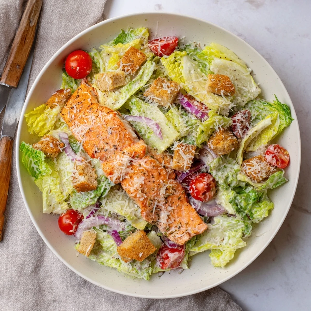 A beautifully plated Salmon Caesar Salad topped with flaky grilled salmon, shaved Parmesan, and cherry tomatoes for a healthy lunch.  