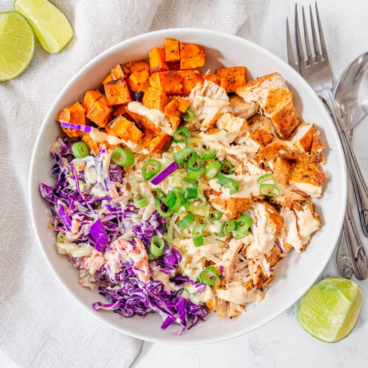 Vibrant meal prep bowl featuring glazed chicken breast sweet potato chunks and creamy coleslaw garnish