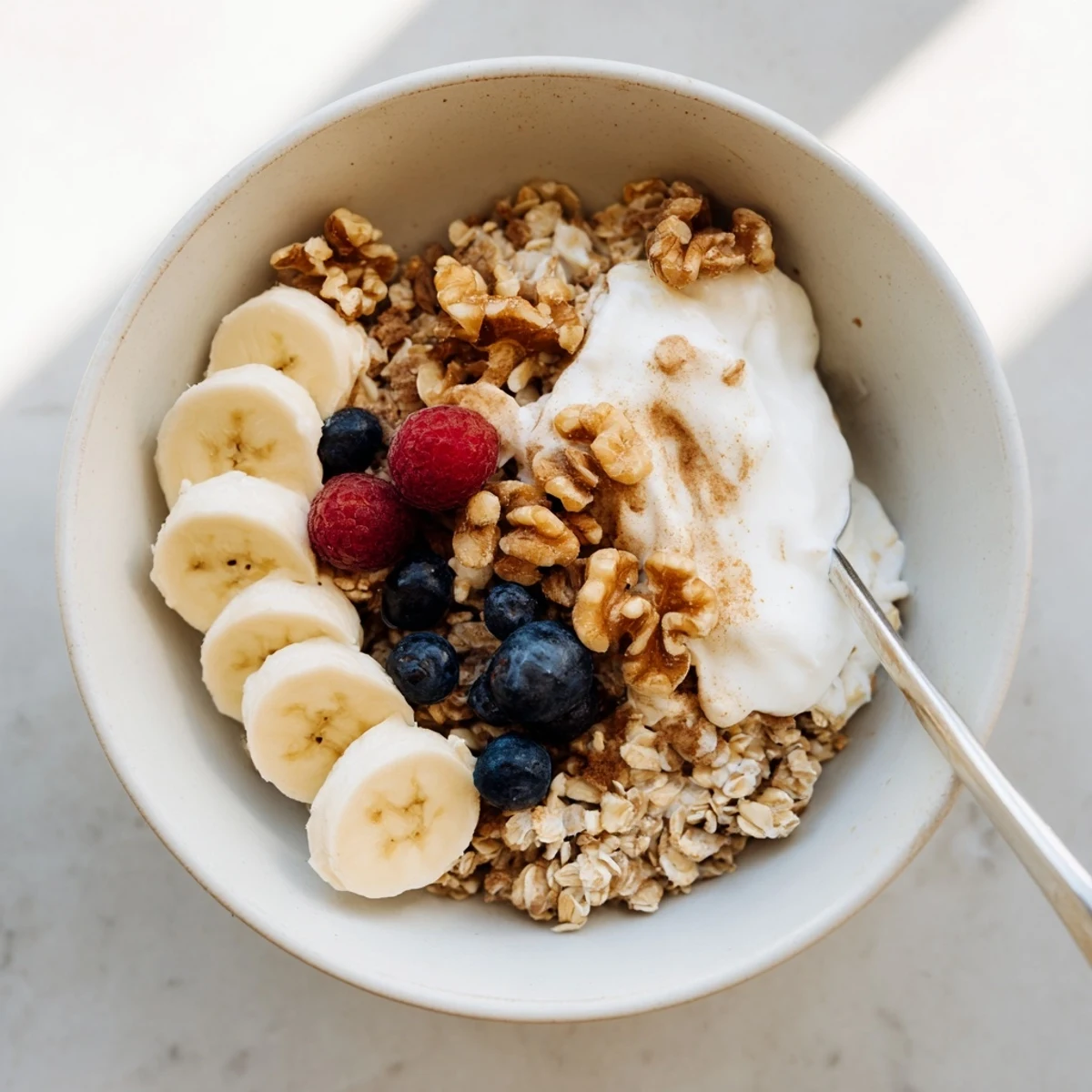 Make-ahead brown sugar overnight oats sprinkled with ground cinnamon and topped with vibrant berries and pecans
