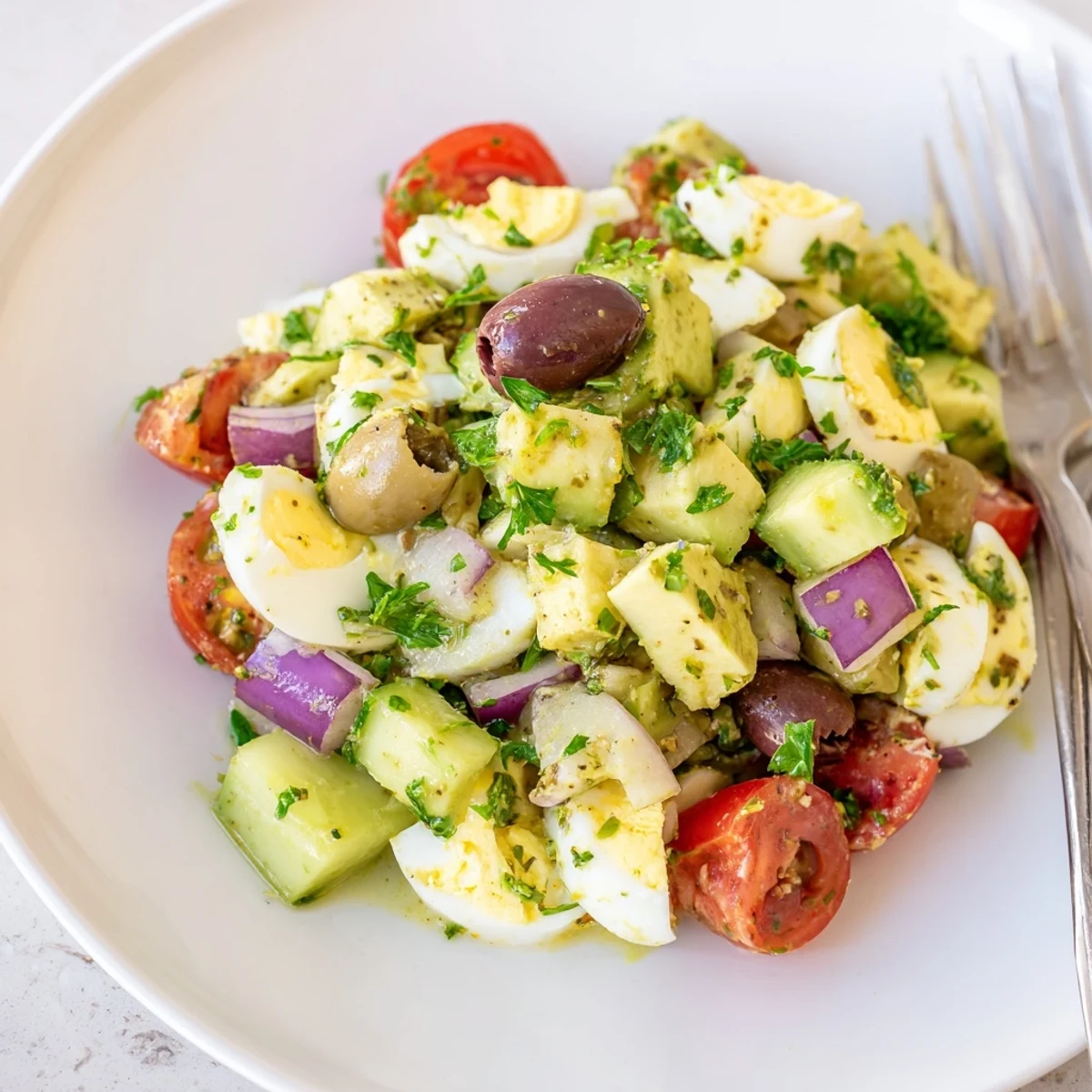 Vibrant bowl of zesty avocado egg salad featuring crisp vegetables and lemon olive oil dressing