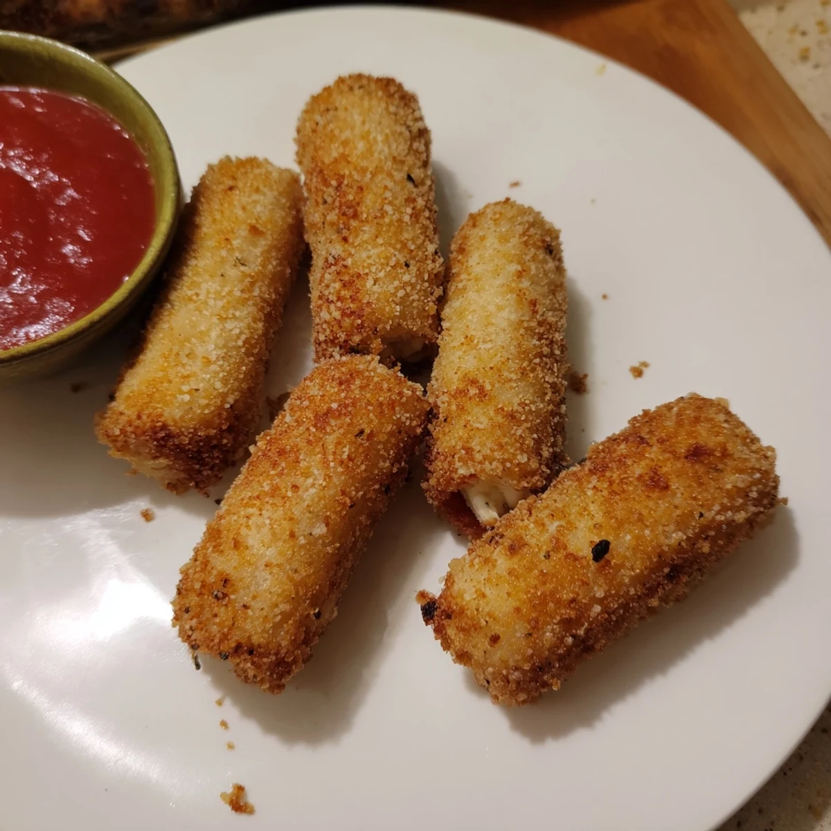Golden crispy cheesy roll ups with melty mozzarella center and garlic parmesan breadcrumb coating