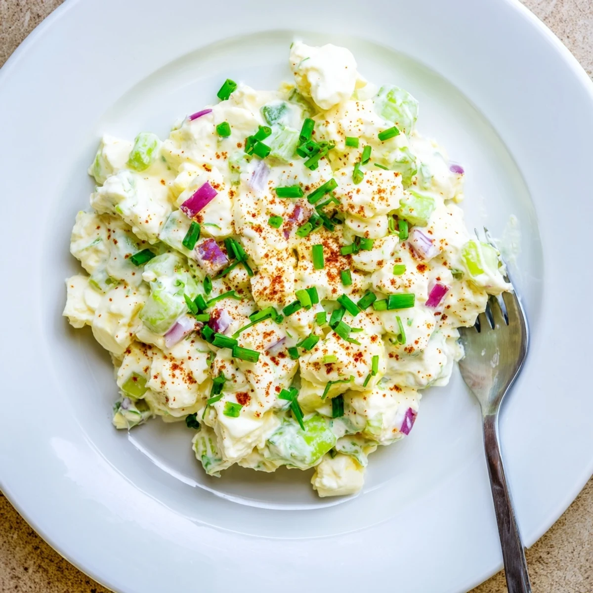 Spoonful of creamy cottage cheese egg salad topped with smoked paprika and fresh parsley garnish
