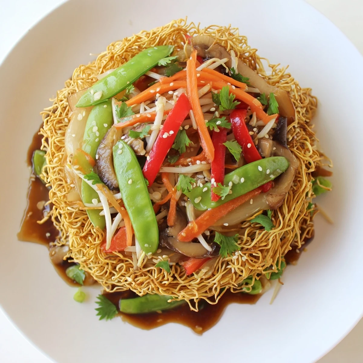 Plate of crispy noodle chow mein with tender bell peppers carrots and crunchy bean sprouts