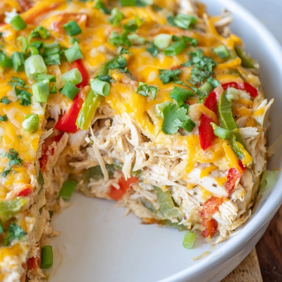 Baked cheesy chicken fajita casserole dish featuring bubbling cheese over seasoned chicken and vegetables
