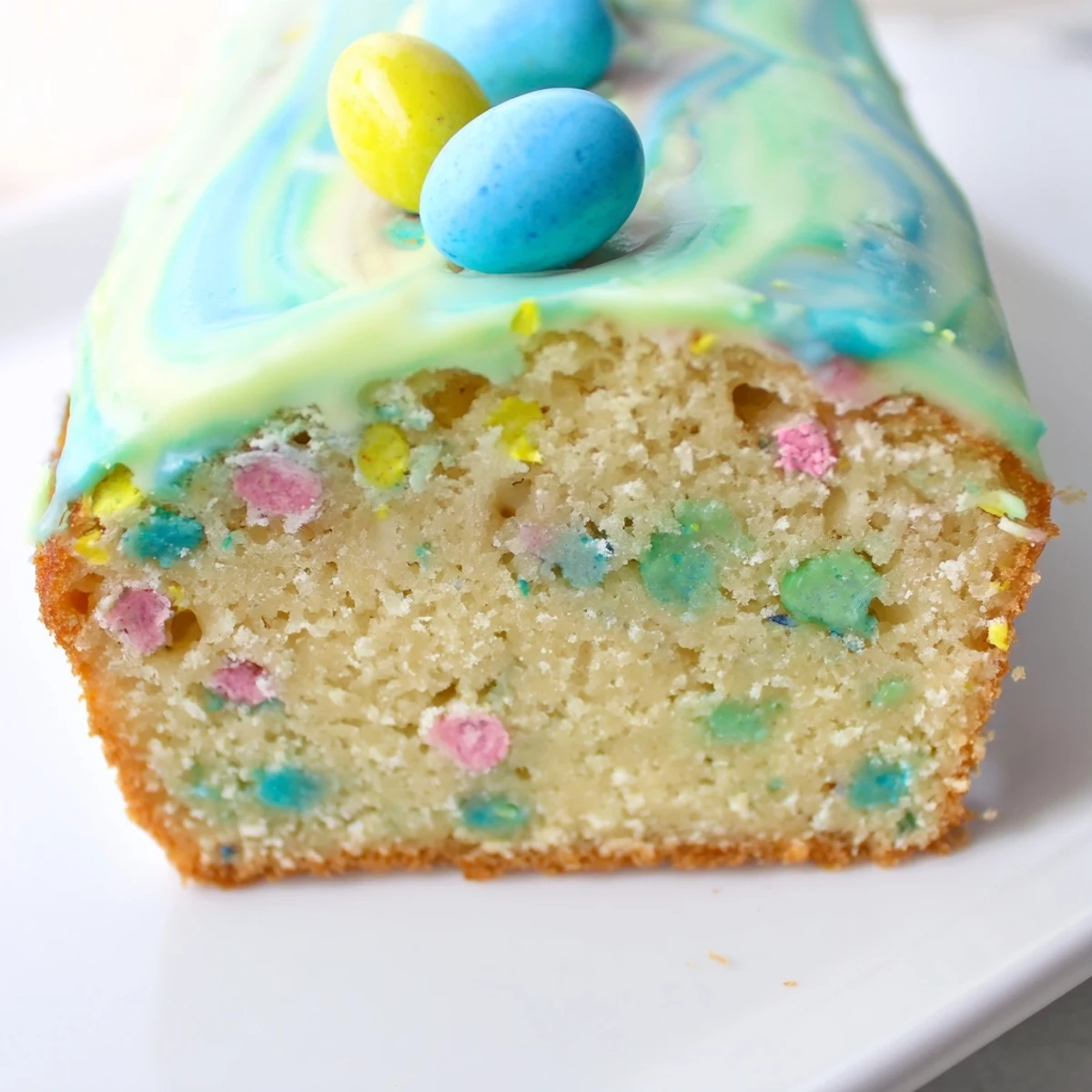 Robin Egg Snack Cake topped with whole candy eggs and drizzled with soft pastel glaze