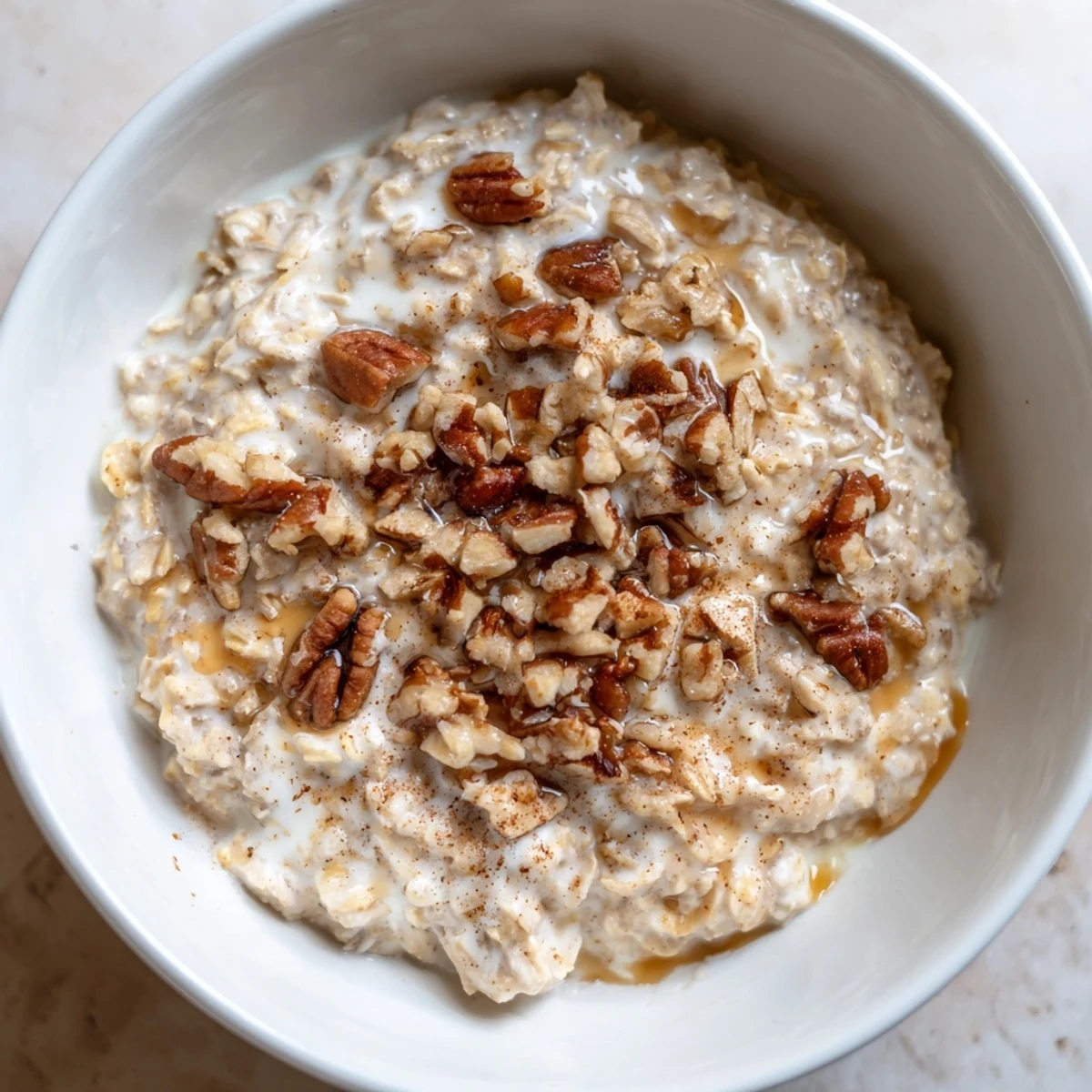 Maple cinnamon pecan overnight oats topped with crunchy pecans and a sweet drizzle