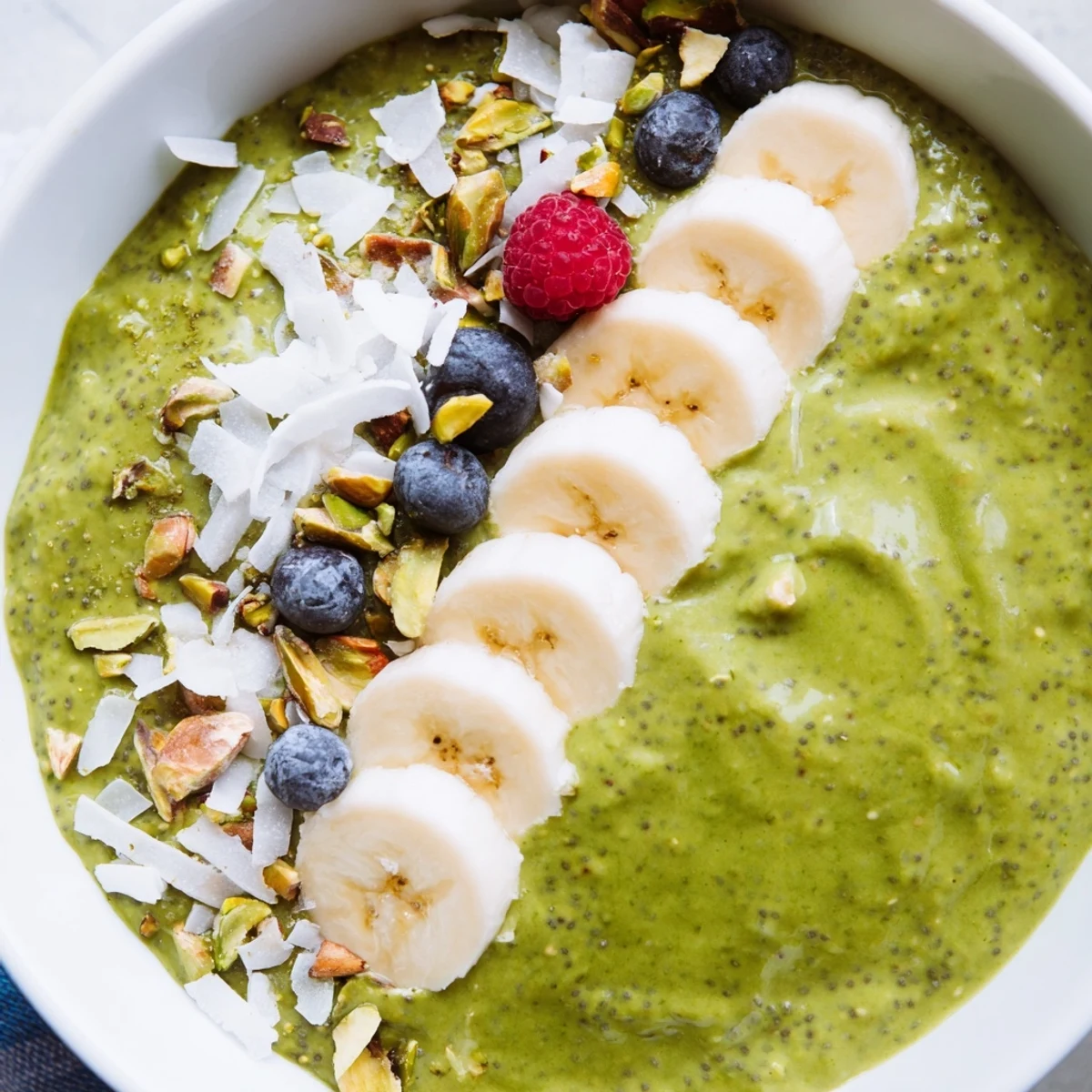 Smooth matcha overnight oats served in a glass jar with crunchy pistachios