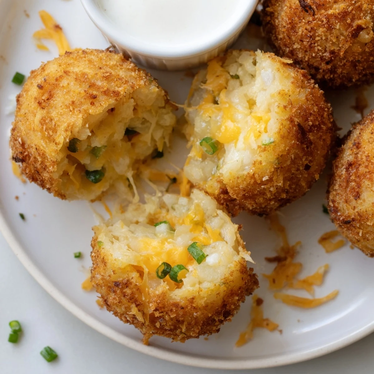 Crispy fried mashed potato balls resting on paper towels, steam rising