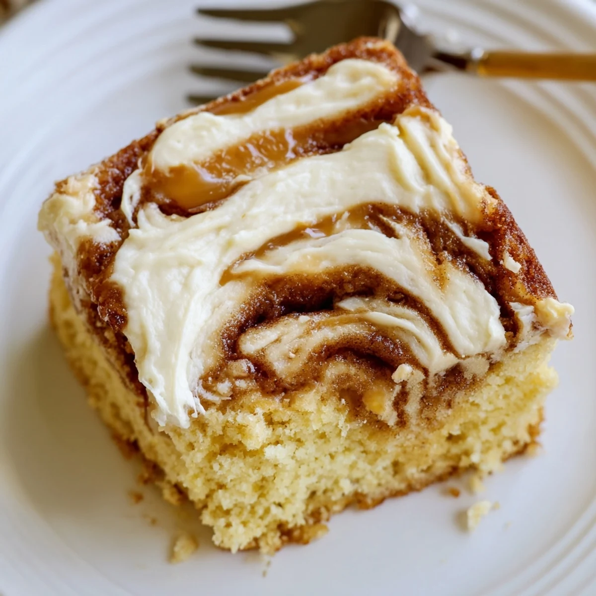 Close-up of Cinnamon Roll Poke Cake slice revealing pockets of cinnamon filling