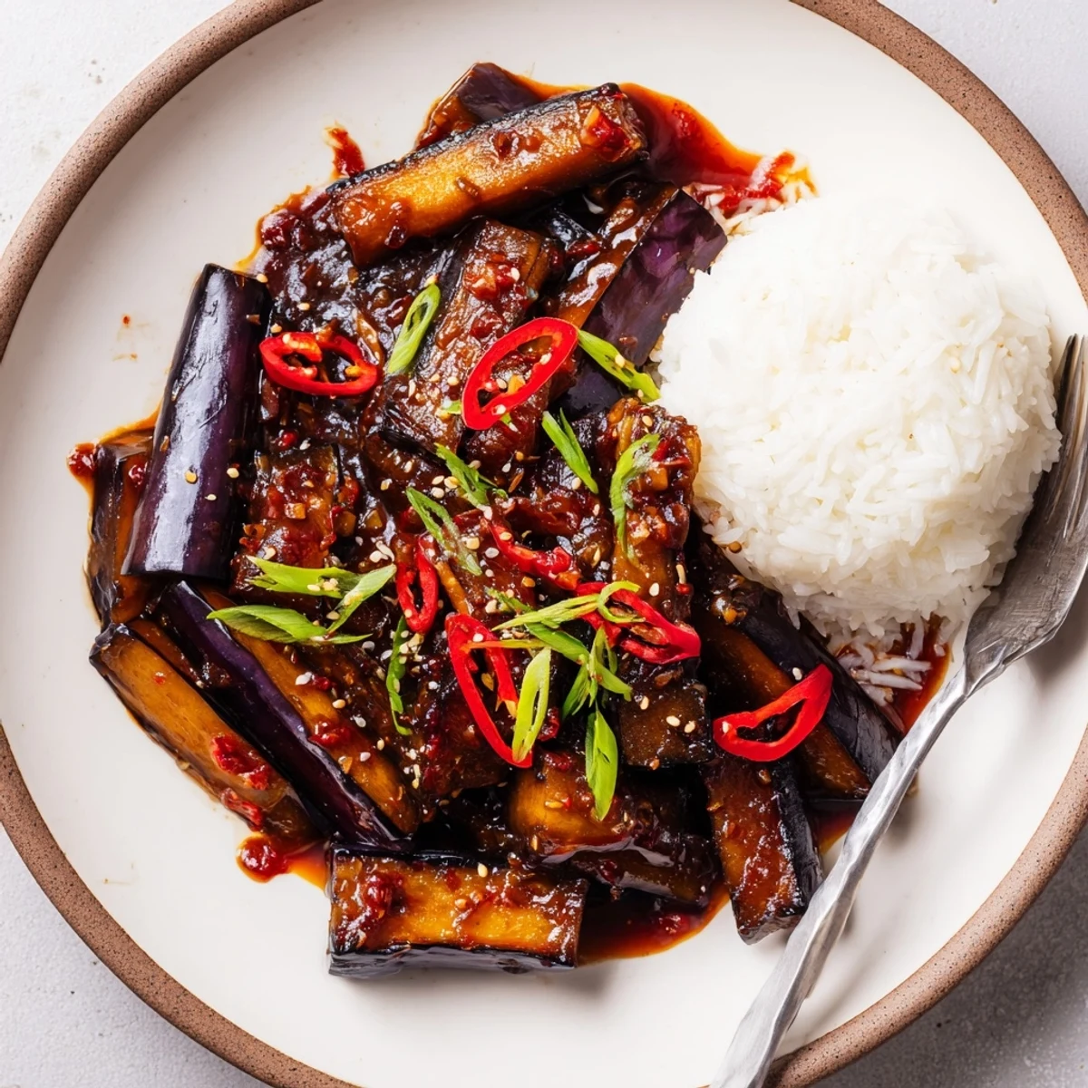 Plate of Sichuan Style Braised Aubergines tossed in aromatic, silky chili sauce.