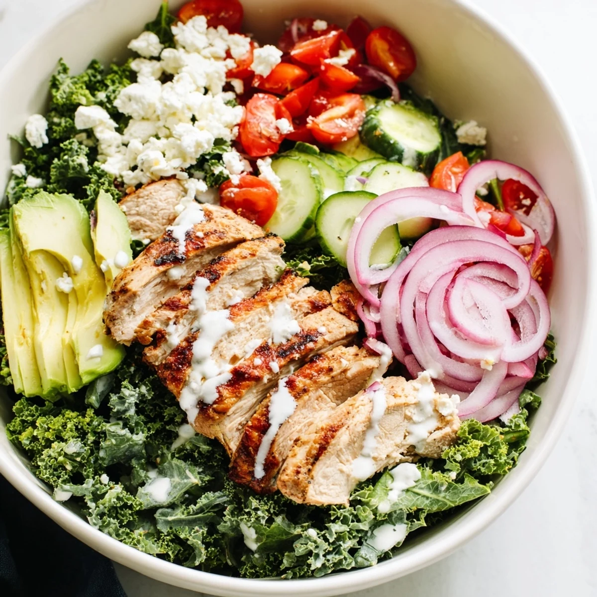 Colorful marinated kale and chicken bowl with fresh vegetables and zesty dressing