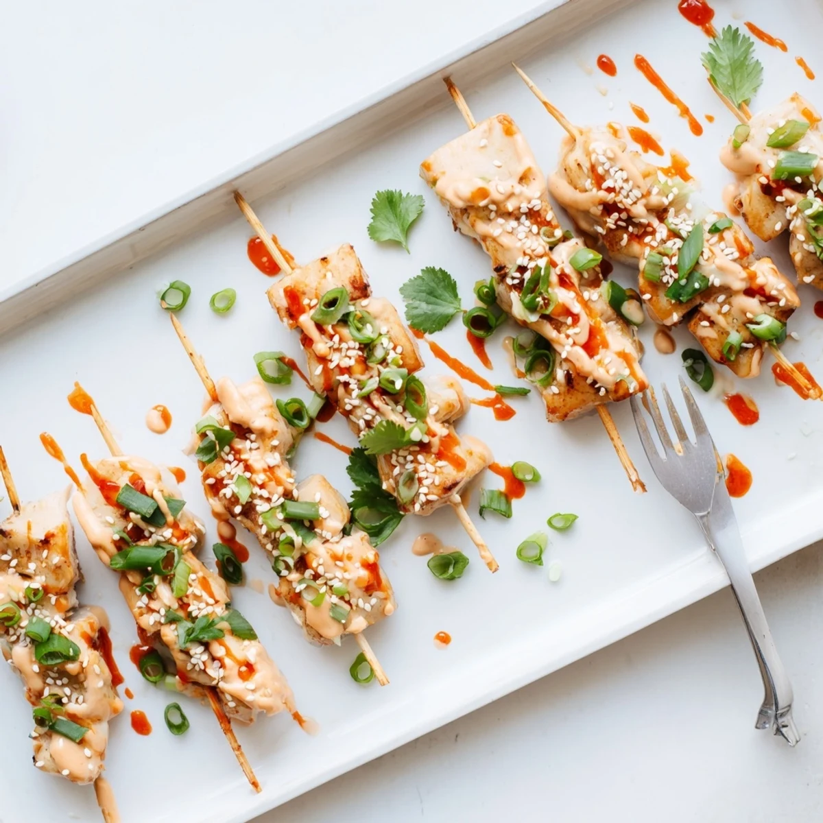 Charred Bang Bang Chicken Skewers brushed with tangy mayonnaise sauce and garnished with fresh scallions
