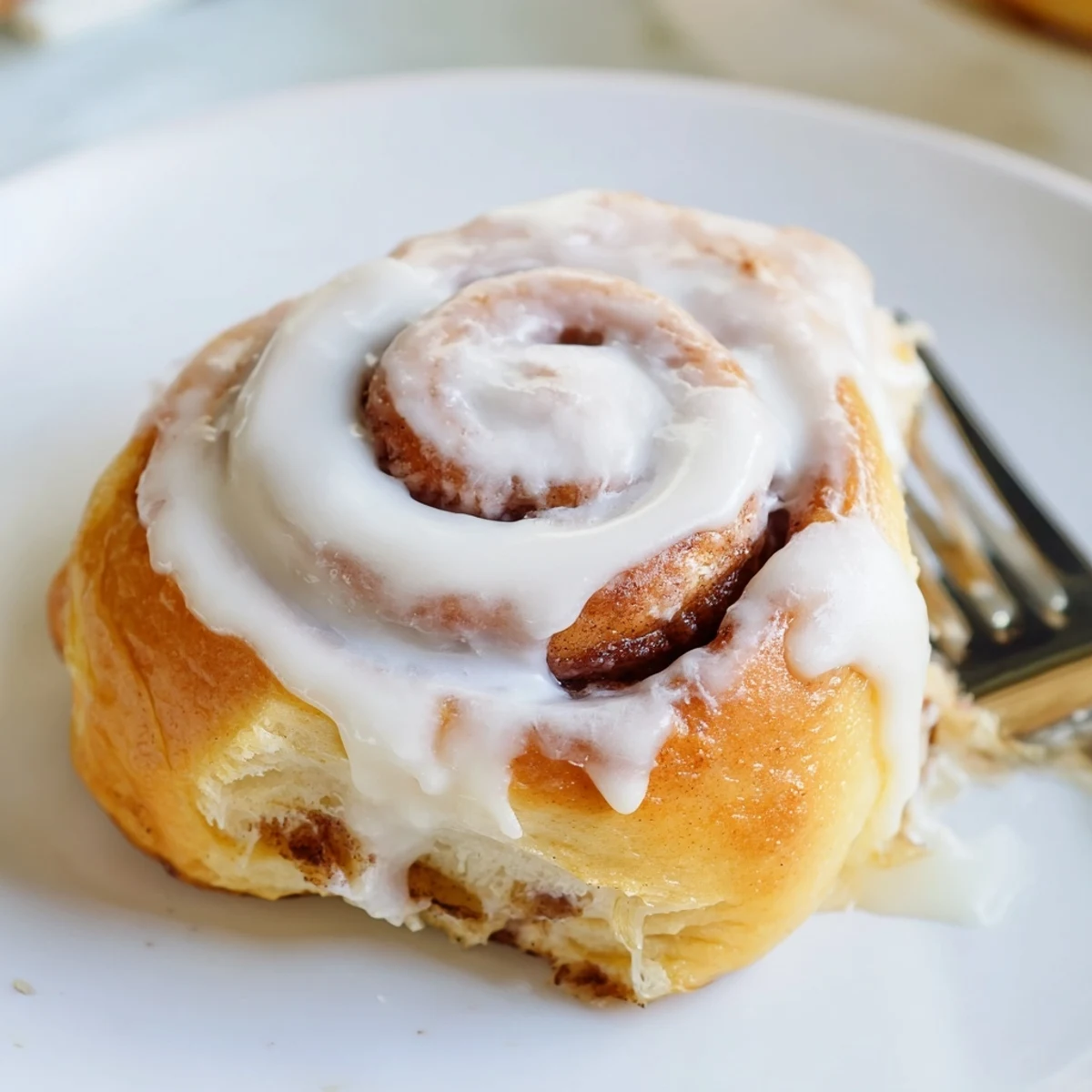 Golden banana cinnamon rolls fresh from the oven with dripping cream cheese glaze