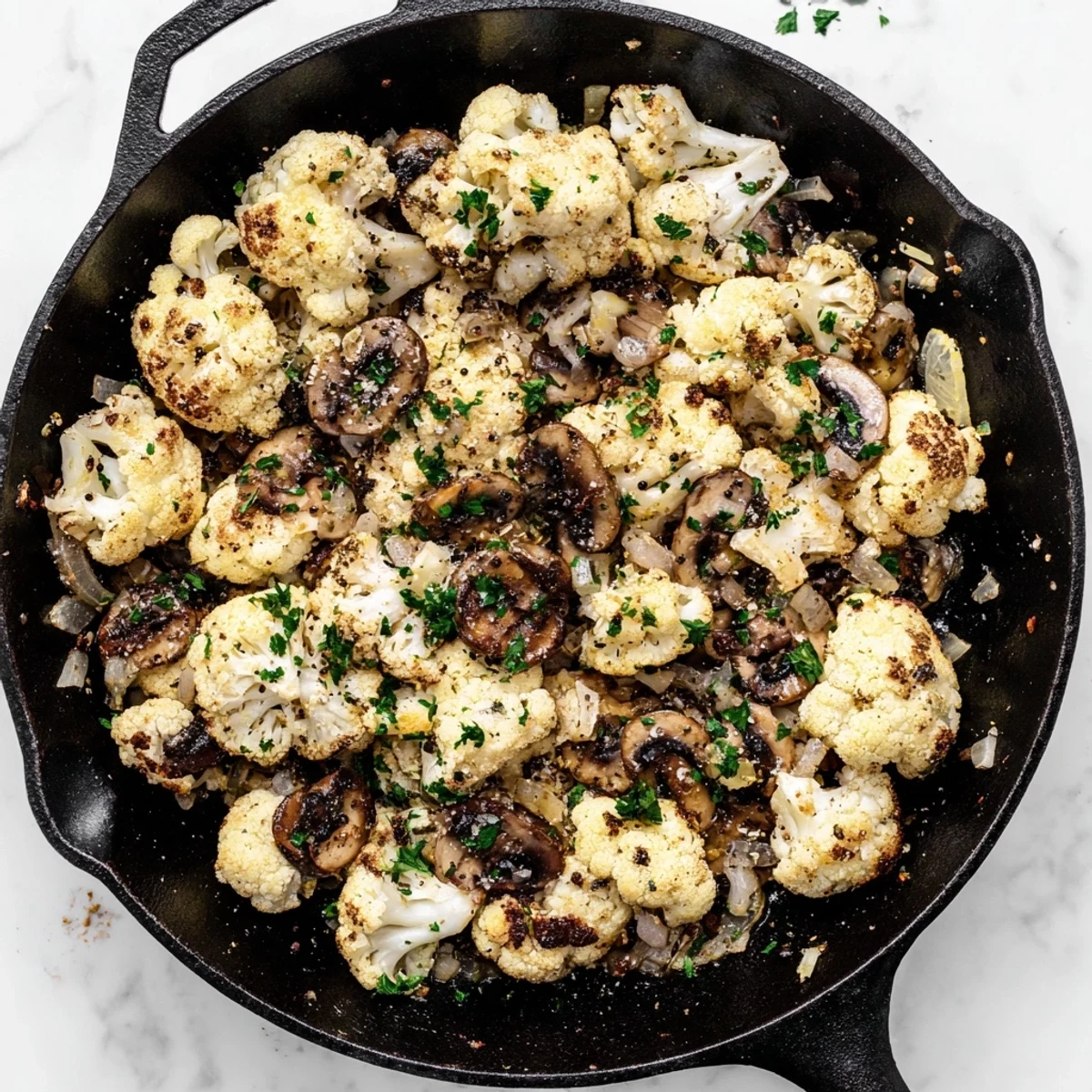 Savory vegetarian garlic mushrooms and cauliflower skillet served steaming hot with lemon and herbs