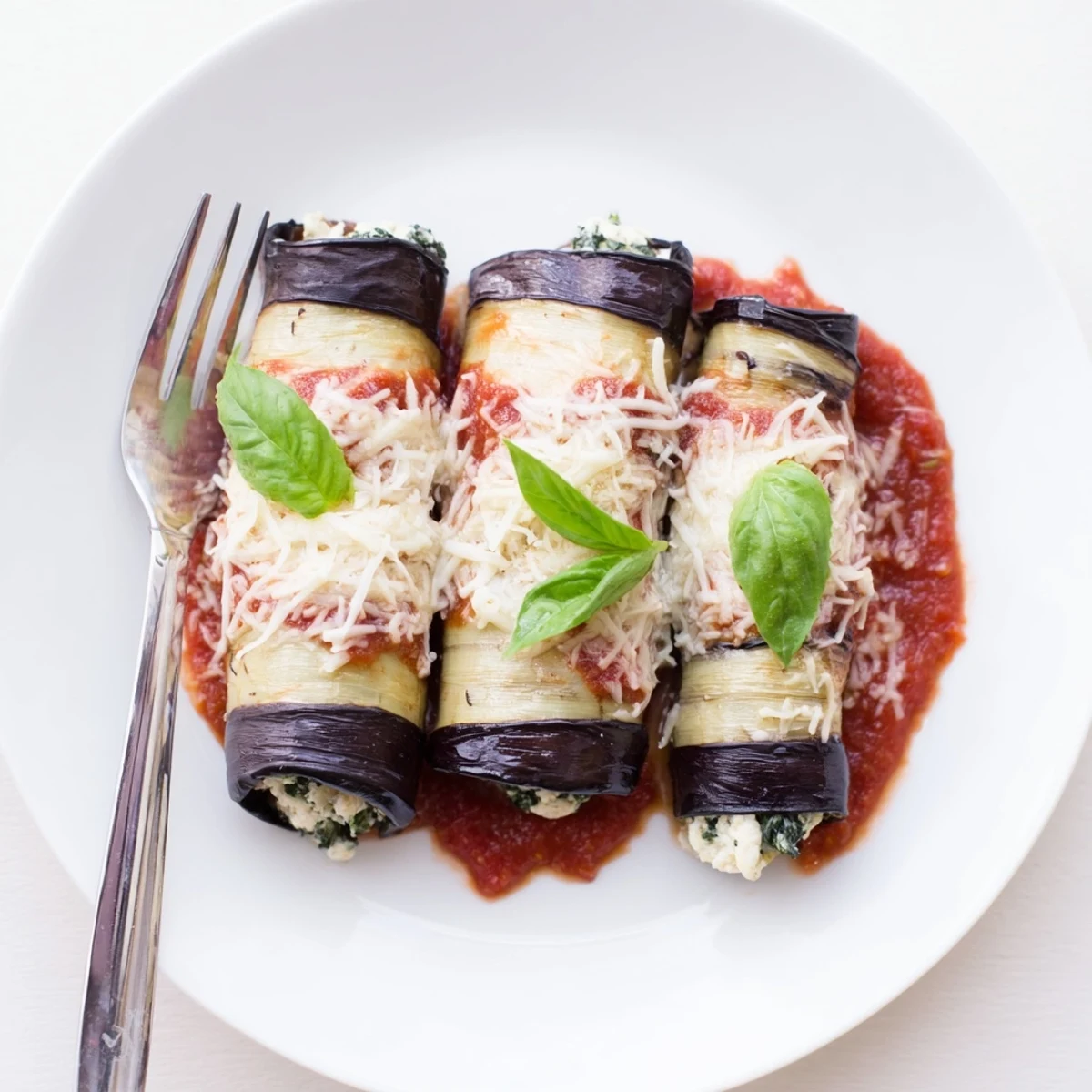Healthy Eggplant Rollatini with creamy ricotta, wilted spinach, bubbling marinara sauce.