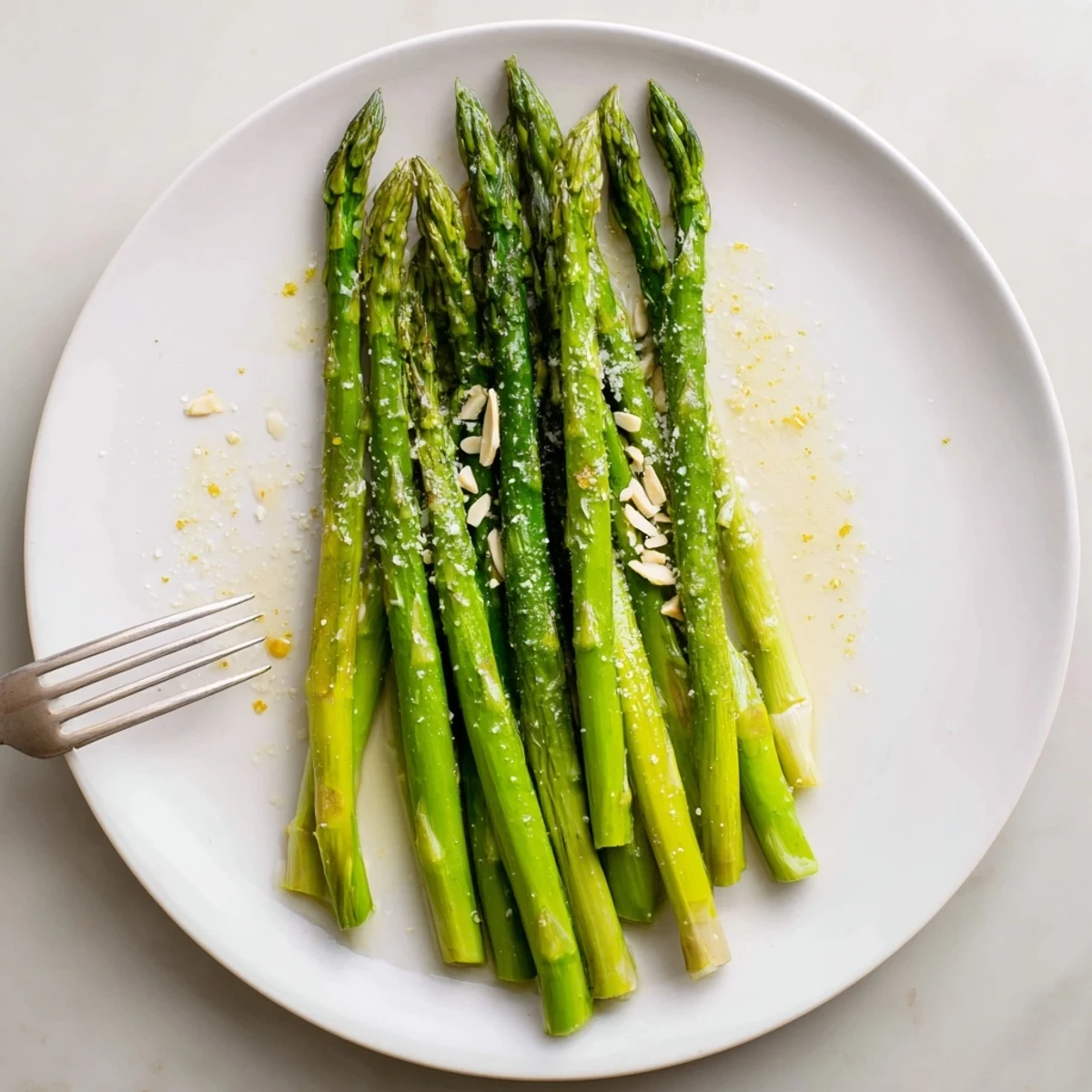 Plate of Steamed Asparagus sprinkled with grated Parmesan, lemon wedge beside