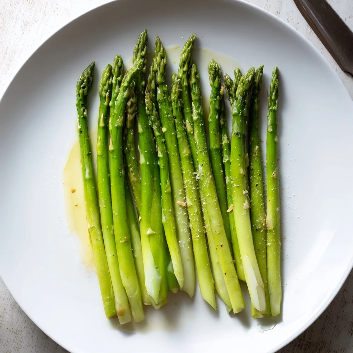 Steamed Asparagus in steamer basket, bright green stalks held by tongs