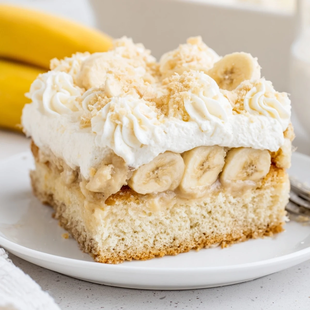 A chilled Banana Pudding Cake Recipe topped with sliced bananas and vanilla wafers