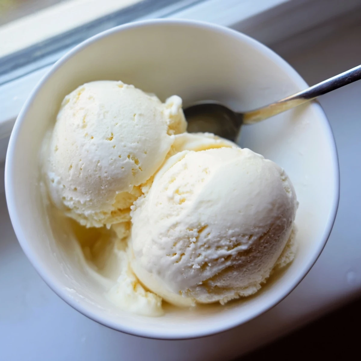 Luscious scoops of vanilla ice cream garnished with chocolate sauce in a chilled dessert bowl