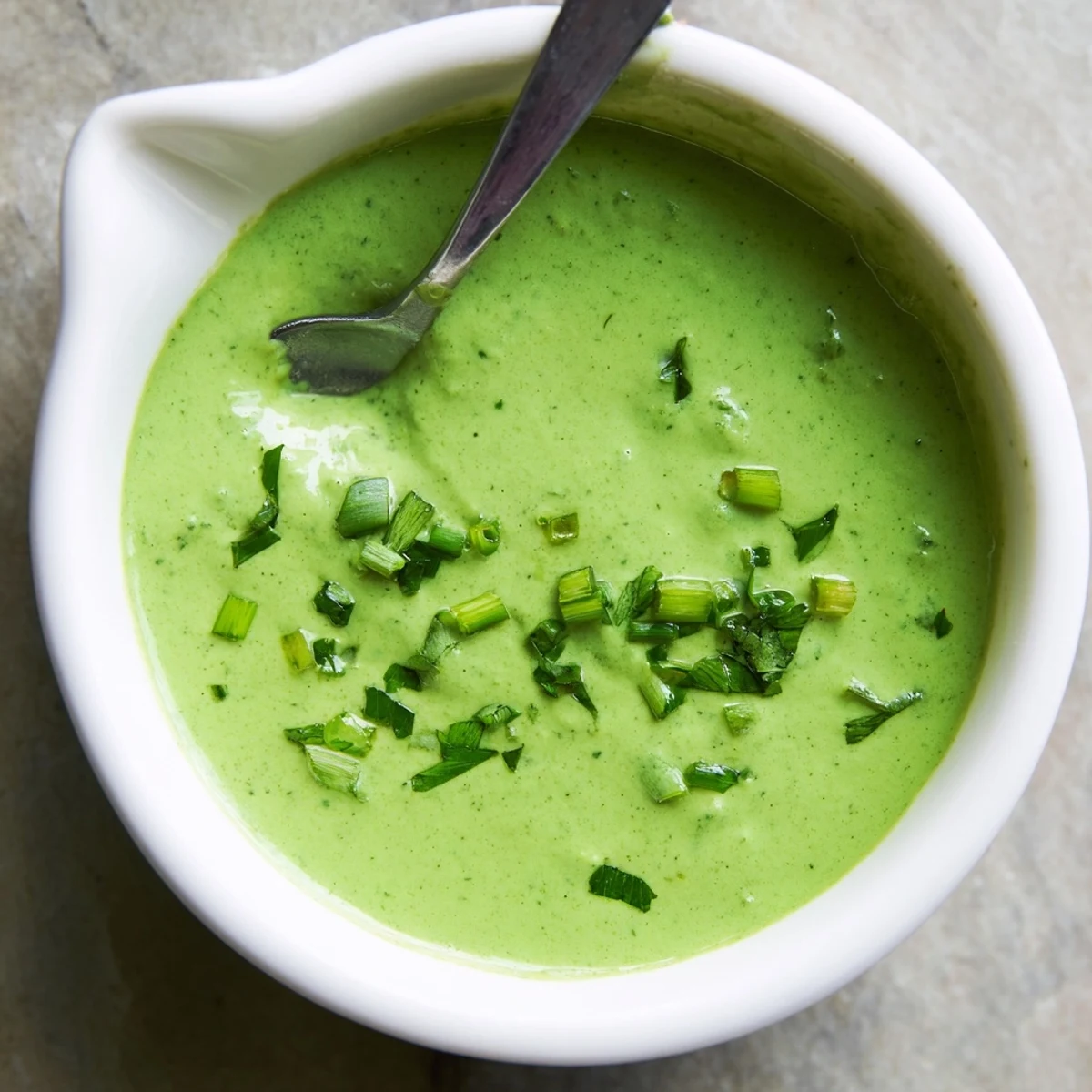Creamy Peruvian green sauce aji verde served in a rustic bowl with fresh cilantro garnish