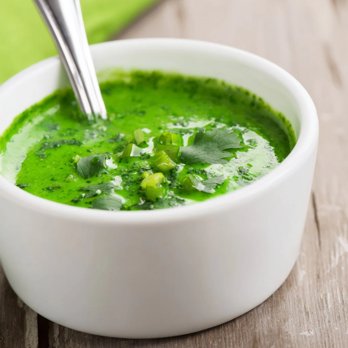 Thick green Peruvian condiment with visible herb specks perfect for dipping crispy fries