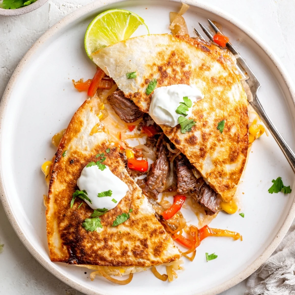 Sweet Savory Beef Quesadillas with melty cheddar, caramelized onions, lime wedge