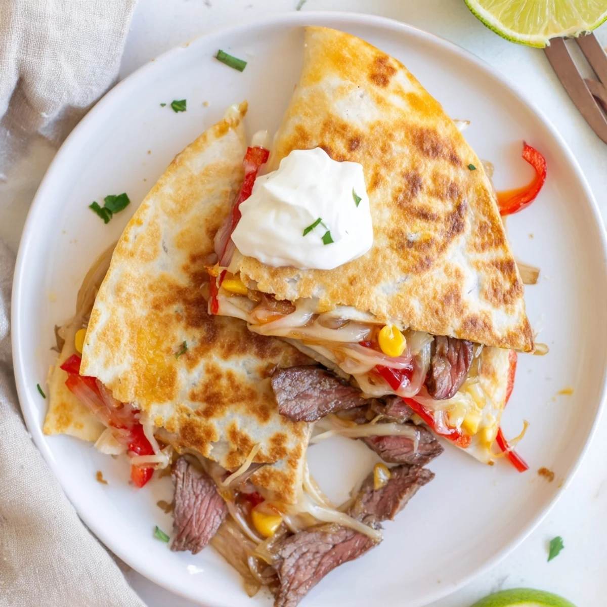 Pan-seared Sweet Savory Beef Quesadillas sliced into golden wedges, served with sour cream
