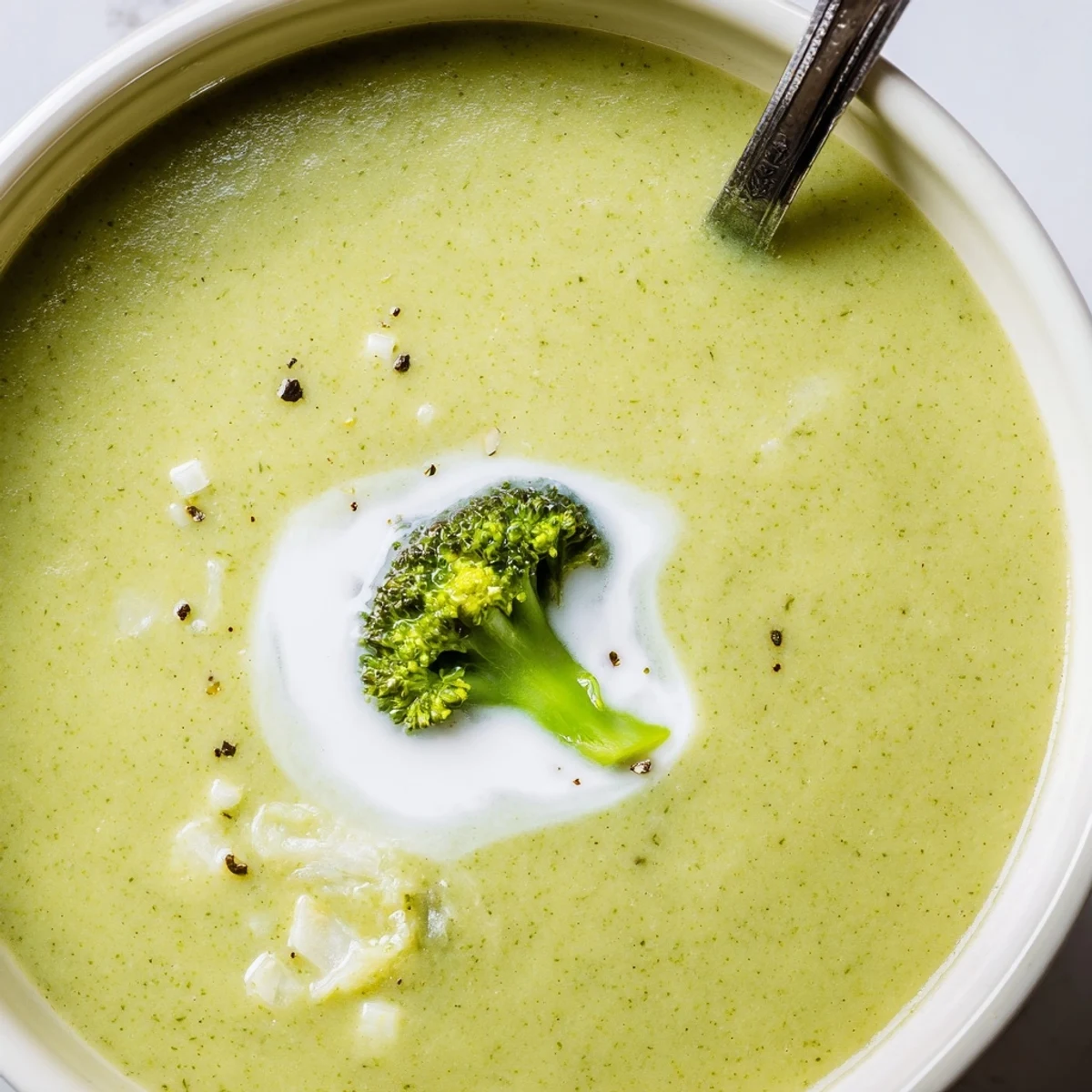 Garlic-scented Broccoli Soup ladled into bowl, topped with toasted seeds