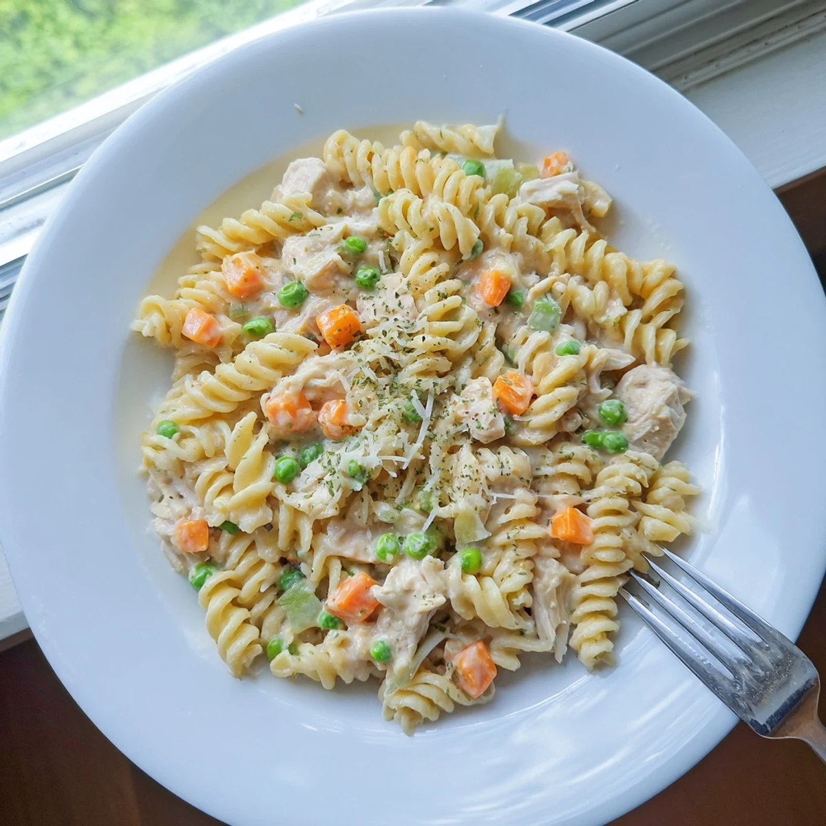Creamy chicken pot pie pasta tossed with tender vegetables in a rich, savory white sauce