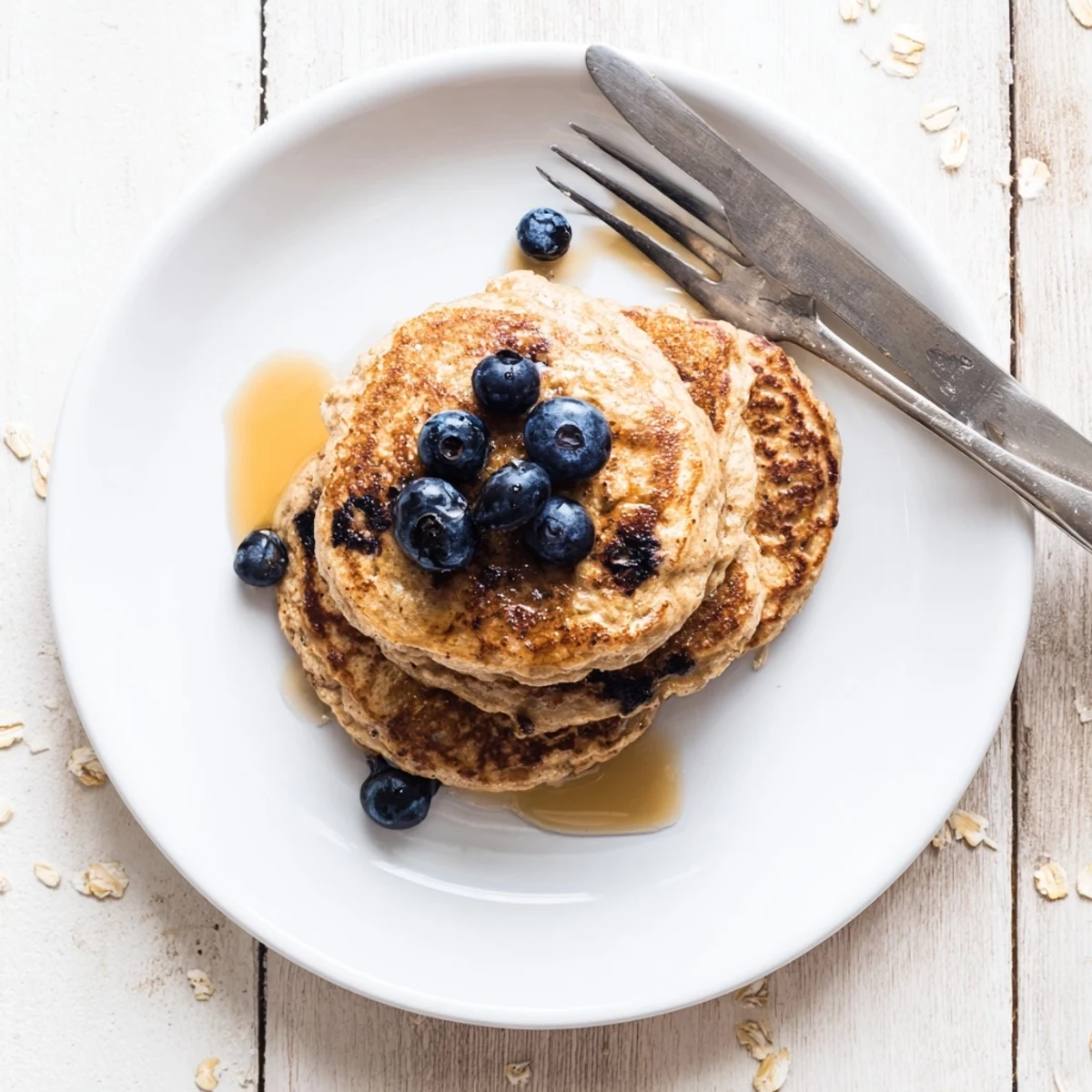 Golden stack of fluffy protein banana pancakes drizzled with maple syrup and fresh berries