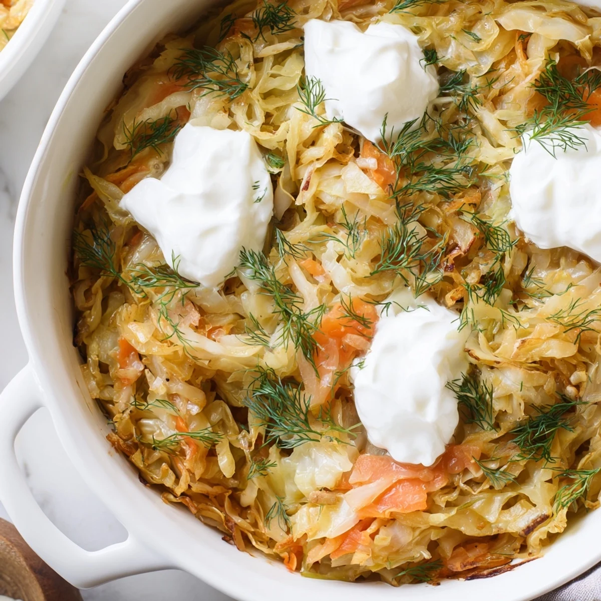 Golden slow roasted cabbage and sauerkraut casserole with tender layers and fresh dill garnish