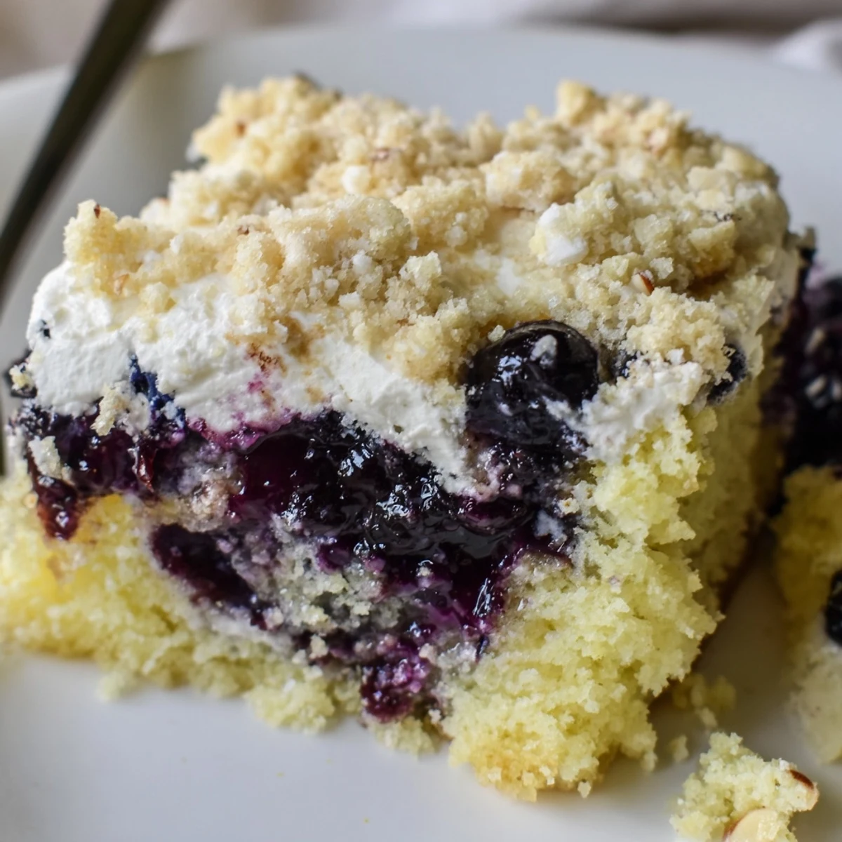 Lemon Blueberry Poke Cake With Almond Topping, zesty lemon crumb with glossy blueberry pockets