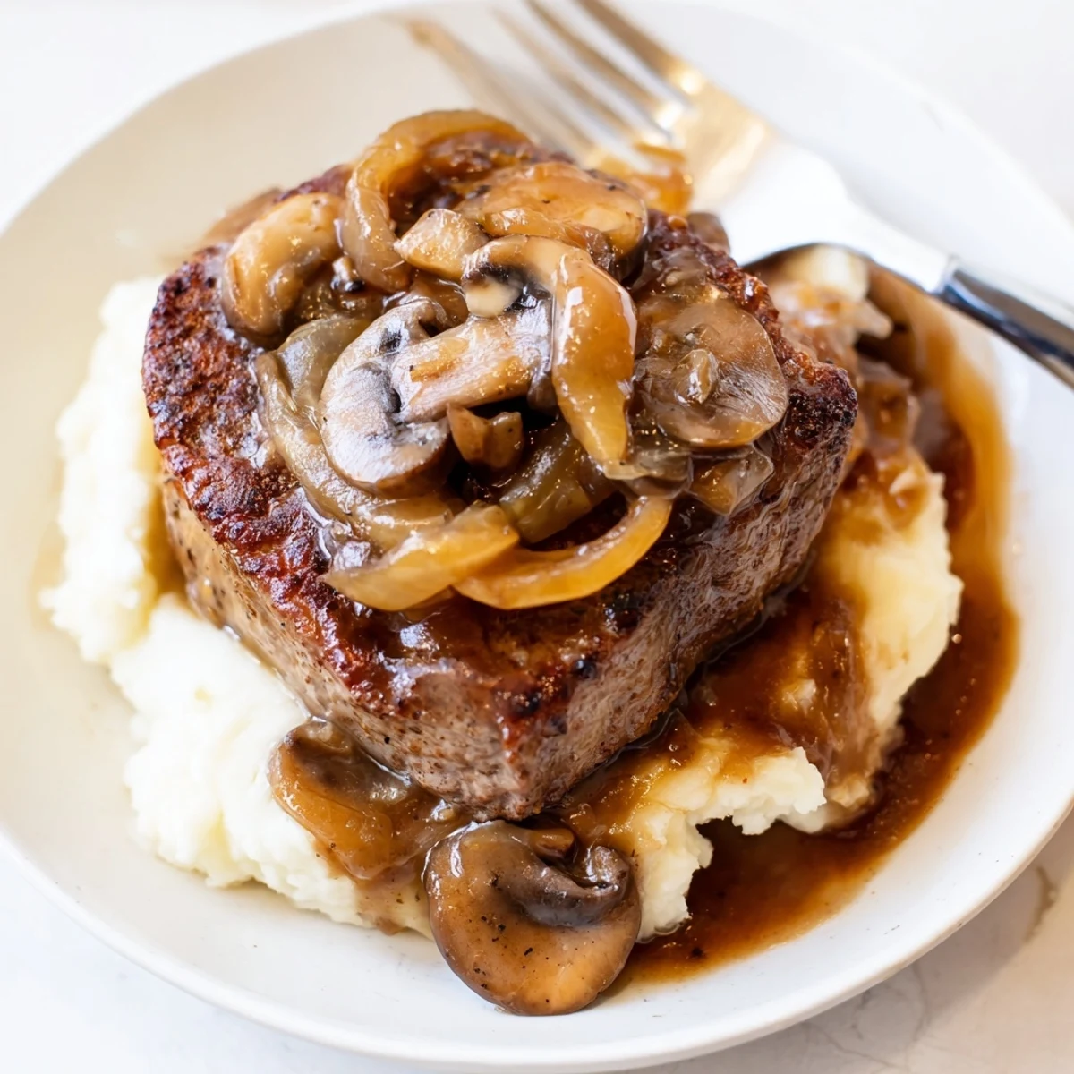 Country Style Smothered Cube Steak Recipe topped with glossy mushroom and onion gravy