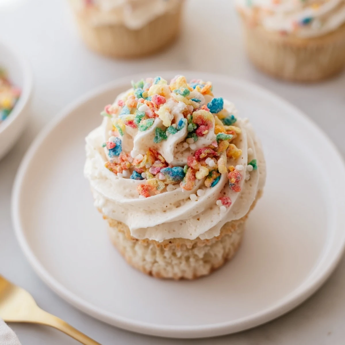 Whipped Fruity Pebbles Cereal Frosting with bright speckles, ready to garnish cake.