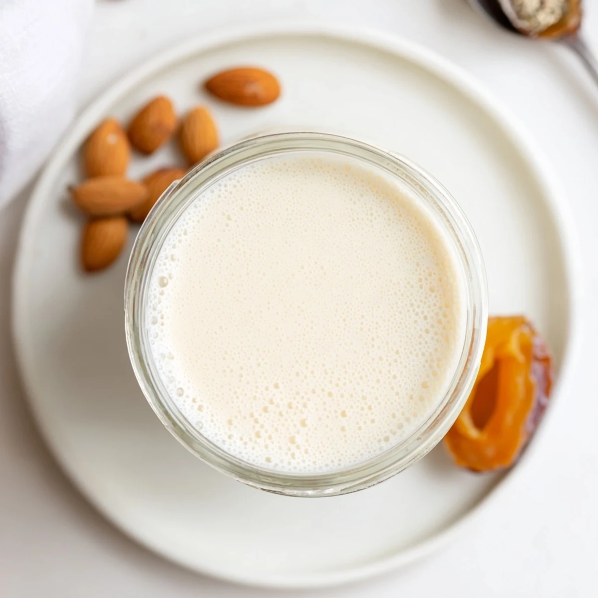 Chilled Almond Milk in mason jar next to blender, ready to shake